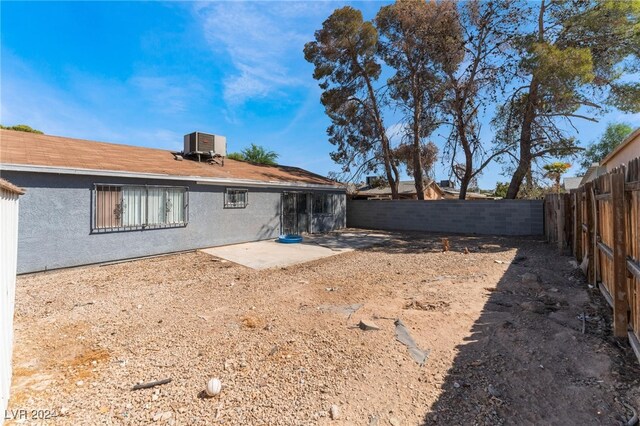 rear view of house featuring central AC unit and a patio area