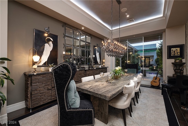 dining space with a chandelier, a tray ceiling, and carpet floors