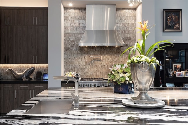 room details with wall chimney range hood and backsplash