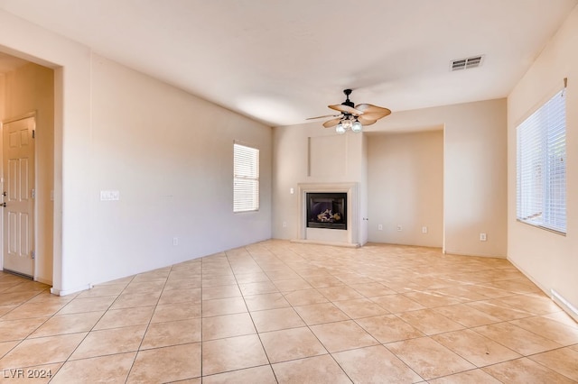 unfurnished living room with ceiling fan and light tile patterned flooring