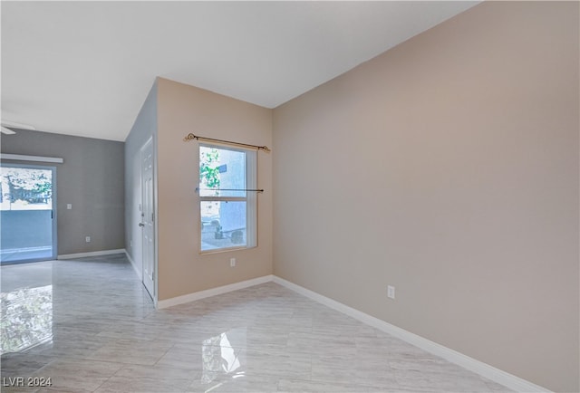 empty room with a wealth of natural light, lofted ceiling, and ceiling fan