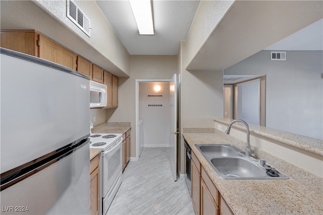 kitchen featuring light brown cabinetry, appliances with stainless steel finishes, and sink