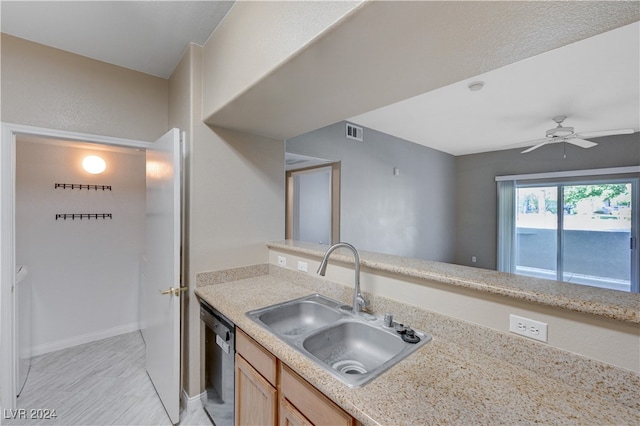 kitchen featuring stainless steel dishwasher, light brown cabinetry, ceiling fan, and sink