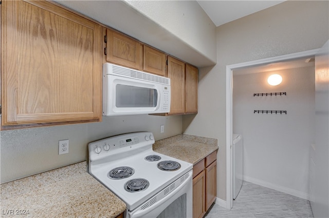 kitchen featuring white appliances and washer / dryer