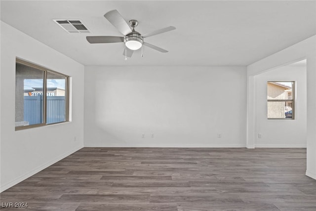 unfurnished room with a wealth of natural light, ceiling fan, and hardwood / wood-style flooring