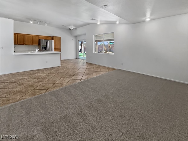 unfurnished living room with sink and light tile patterned floors