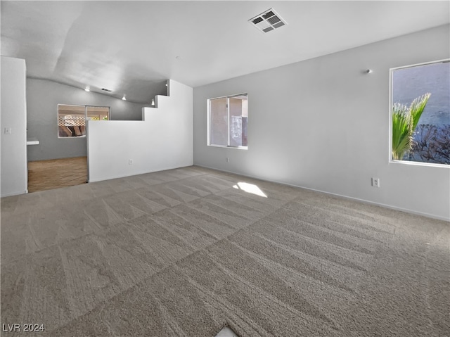 spare room featuring lofted ceiling and carpet