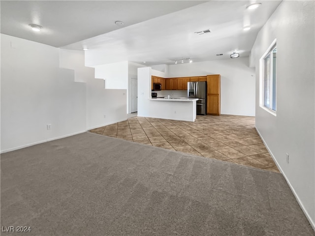 unfurnished living room featuring light carpet and sink