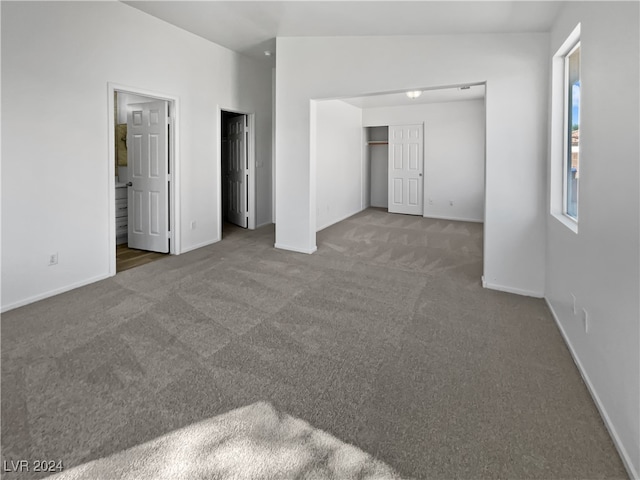 carpeted empty room featuring vaulted ceiling