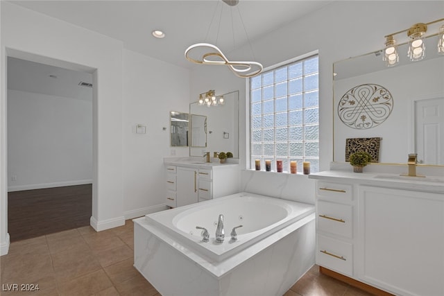 bathroom featuring a notable chandelier, a bathing tub, vanity, and hardwood / wood-style flooring