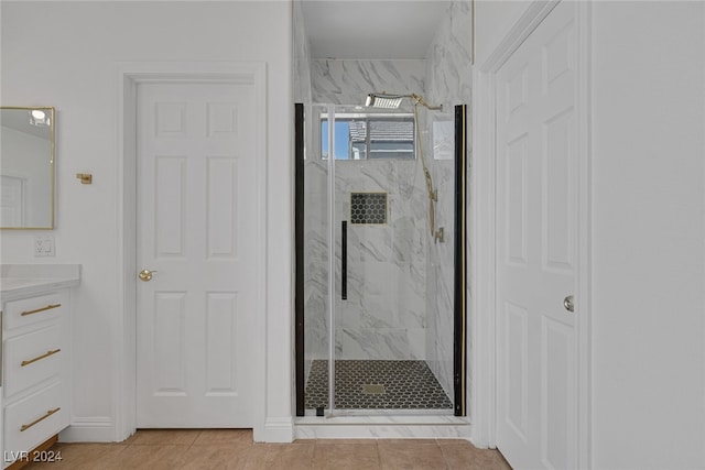 bathroom with walk in shower, vanity, and tile patterned floors