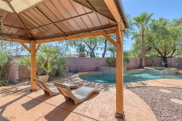 view of swimming pool with a patio, an in ground hot tub, and a gazebo