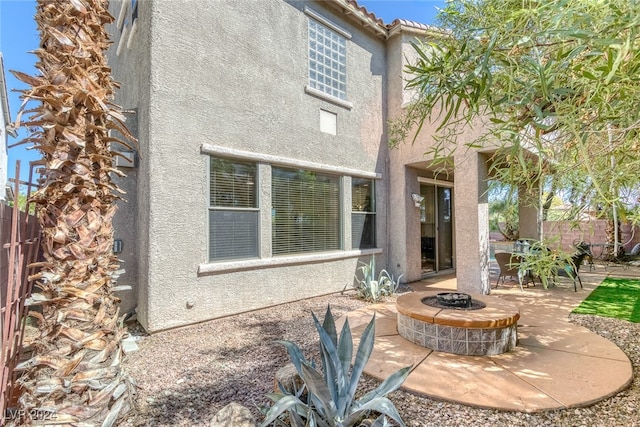 rear view of property with a patio area and a fire pit