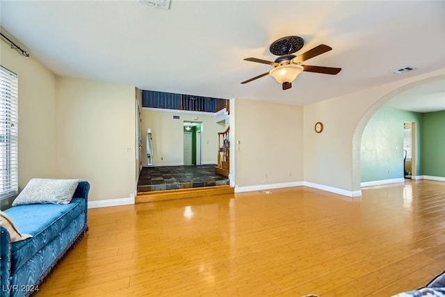 unfurnished living room featuring ceiling fan and hardwood / wood-style flooring