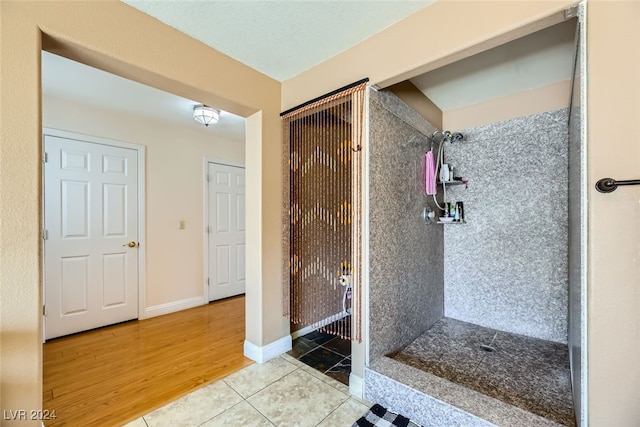 bathroom featuring wood-type flooring and tiled shower