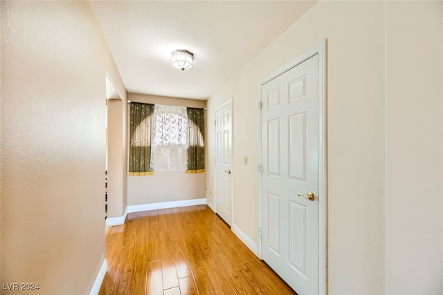 corridor with hardwood / wood-style flooring