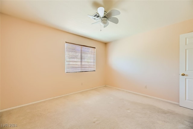 spare room with ceiling fan and light carpet