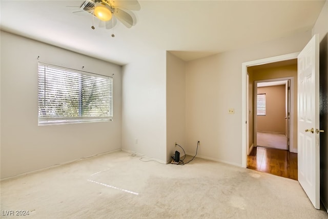 carpeted spare room featuring ceiling fan