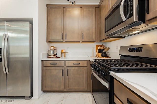 kitchen featuring stainless steel appliances and light stone counters