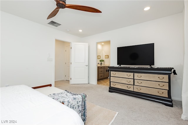 carpeted bedroom featuring ensuite bath and ceiling fan