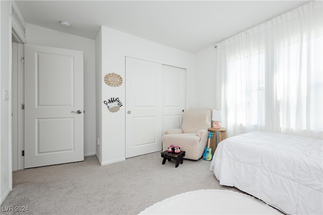 bedroom with light carpet and a closet