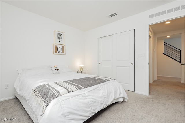 bedroom with light colored carpet and a closet