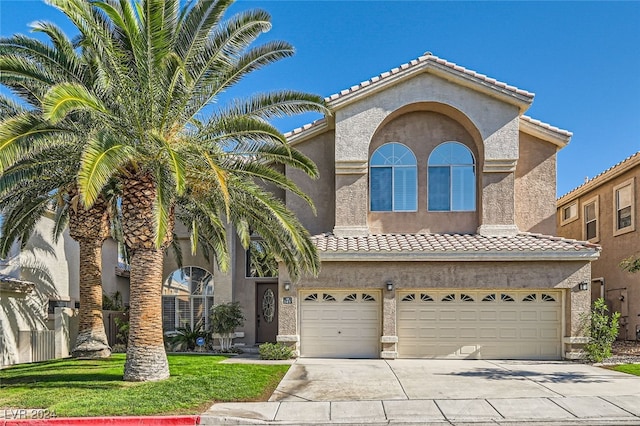 mediterranean / spanish-style home with a front lawn and a garage