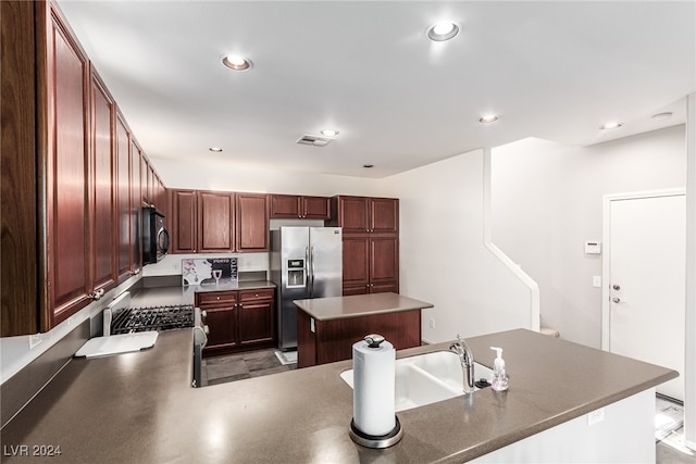 kitchen featuring a center island, sink, stainless steel appliances, and concrete flooring