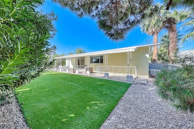 back of house featuring a patio area and a lawn