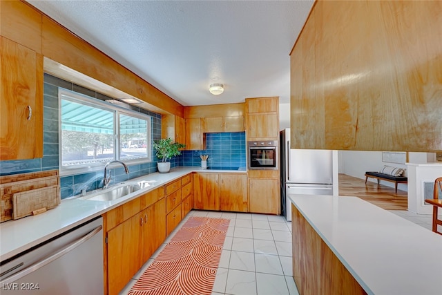 kitchen with sink, decorative backsplash, stainless steel appliances, and light tile patterned floors