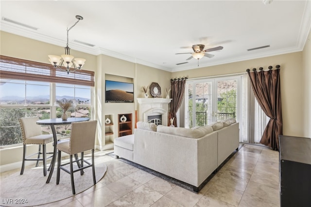 living room with ceiling fan with notable chandelier and crown molding