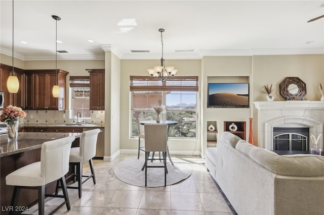 kitchen with backsplash, ornamental molding, pendant lighting, and dark brown cabinetry