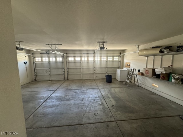 garage with a garage door opener and washer / clothes dryer