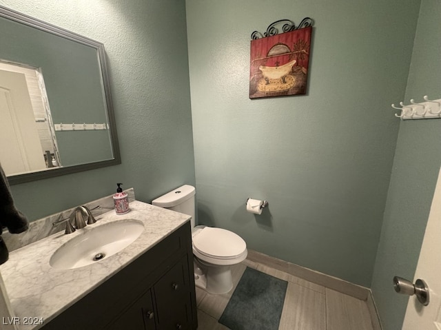 bathroom featuring tile patterned flooring, vanity, and toilet