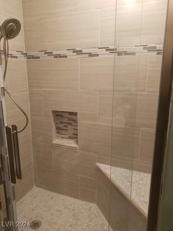 bathroom with a shower with door