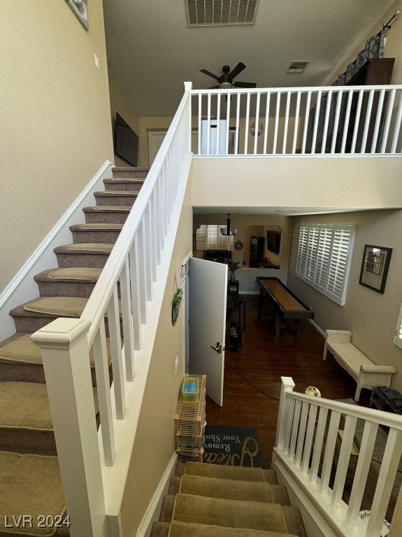 staircase featuring ceiling fan