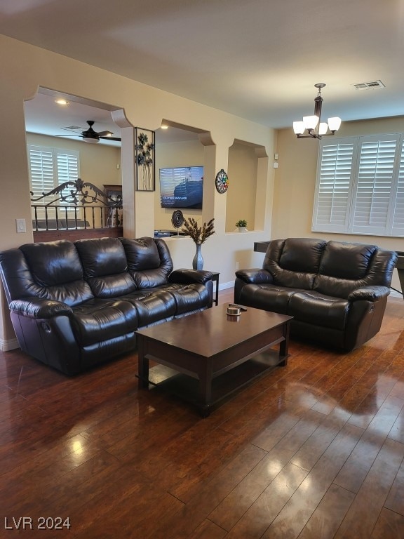 living room featuring ceiling fan with notable chandelier and dark hardwood / wood-style floors