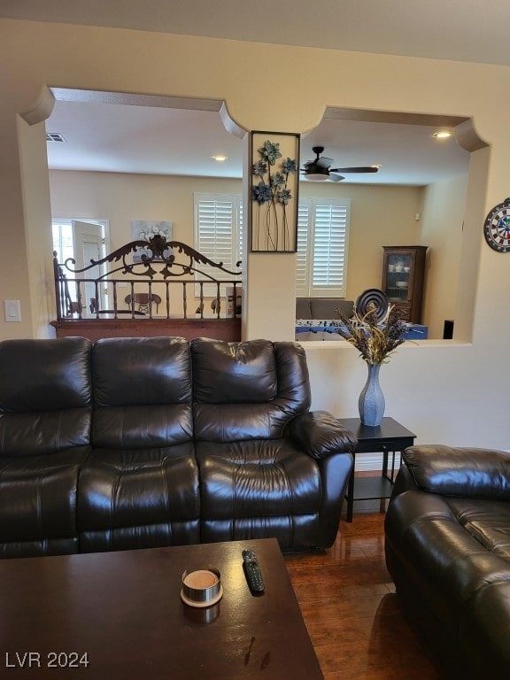 living room featuring ceiling fan and dark wood-type flooring