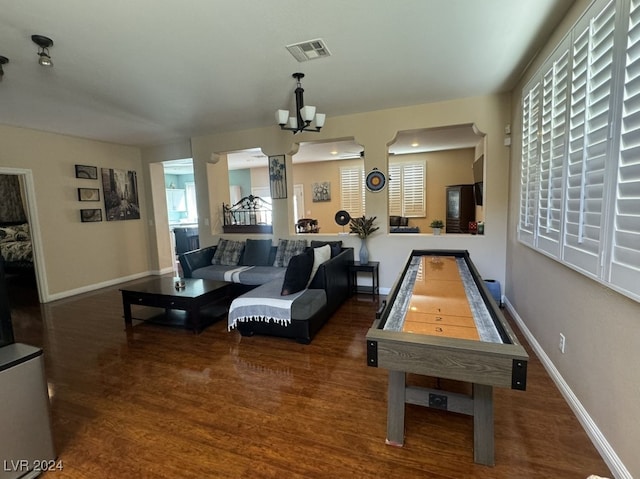 game room featuring dark hardwood / wood-style floors and a chandelier