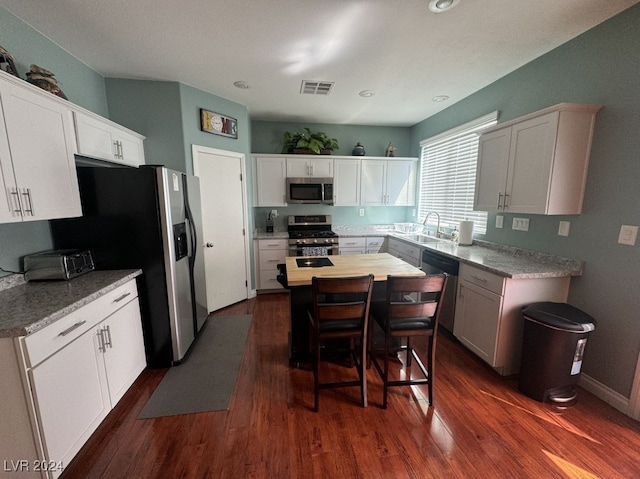 kitchen with sink, stainless steel appliances, dark hardwood / wood-style flooring, and white cabinetry