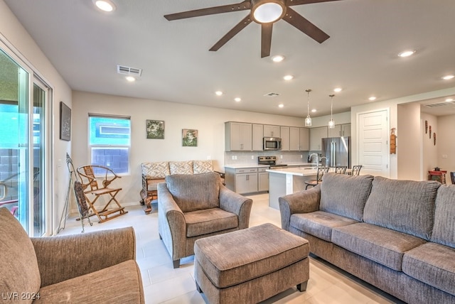 living room featuring light tile patterned flooring, ceiling fan, visible vents, and recessed lighting