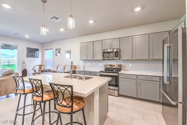 kitchen with appliances with stainless steel finishes, light countertops, hanging light fixtures, and visible vents