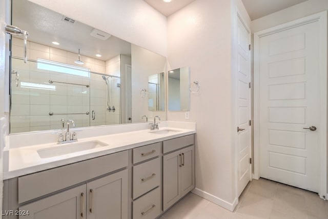 bathroom with double vanity, a stall shower, tile patterned flooring, and a sink