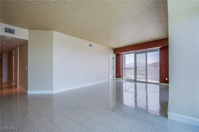 unfurnished room with a textured ceiling