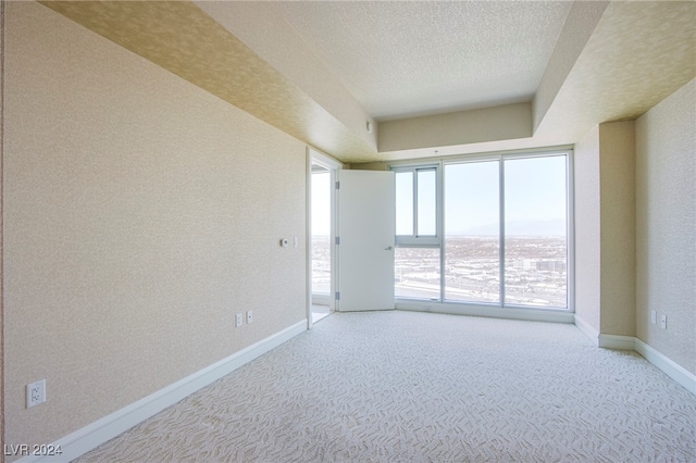 carpeted spare room featuring a textured ceiling and a water view