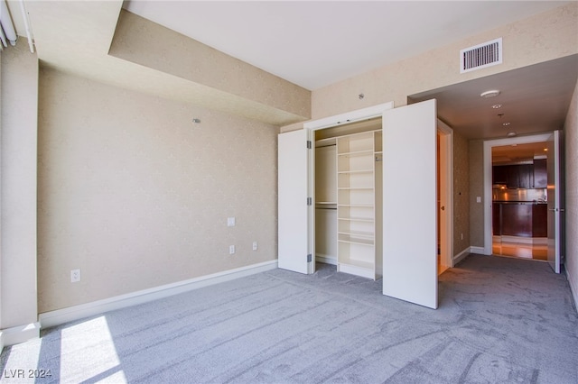 unfurnished bedroom with a closet and carpet flooring