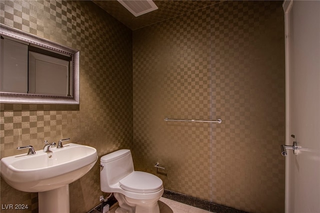 bathroom featuring sink, tile walls, and toilet