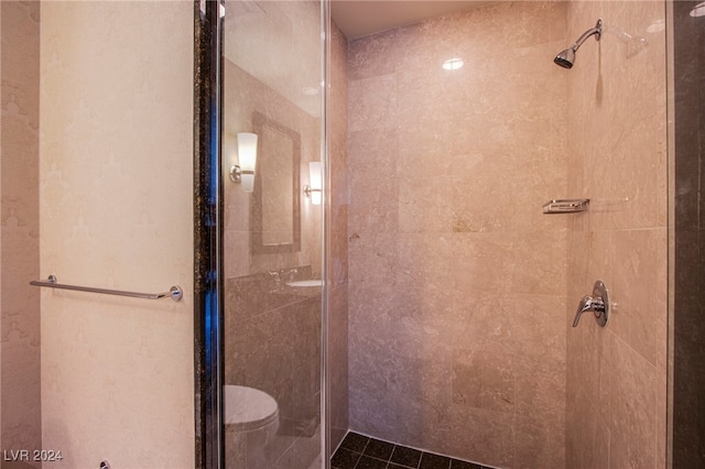 bathroom featuring toilet and a shower with shower door