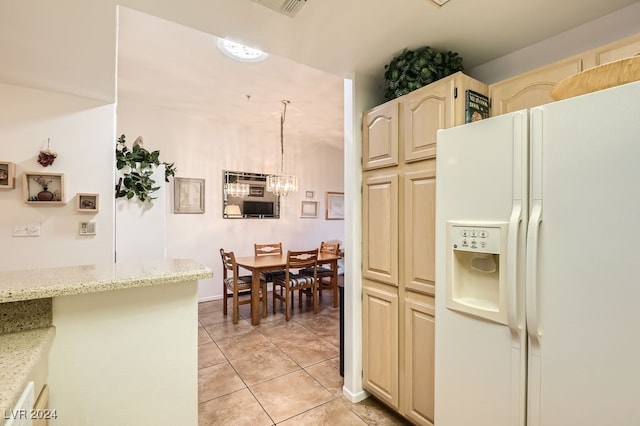 kitchen featuring white fridge with ice dispenser, pendant lighting, light stone counters, and light tile patterned floors