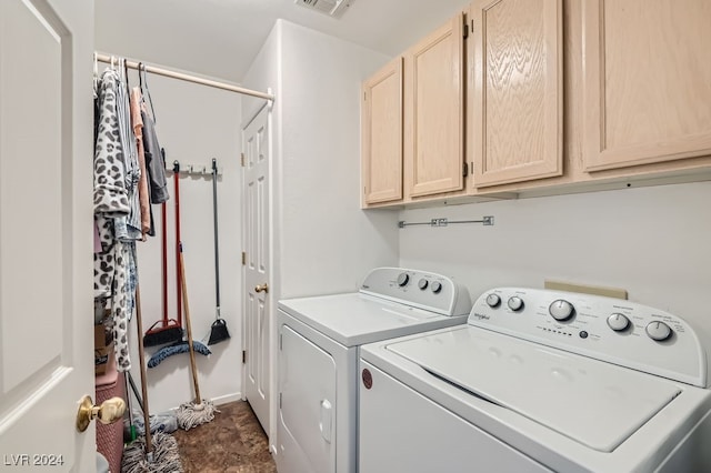 clothes washing area with cabinets and washer and dryer